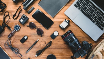all kinds of tech gadgets laid out on a wooden table
