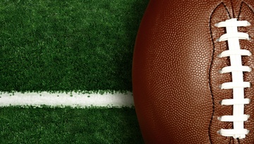 American football sitting on a field