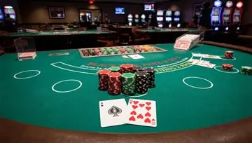 Blackjack table with chips stacked up and an A and 10 showing