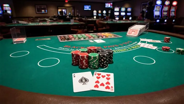 Blackjack table with chips stacked up and an A and 10 showing