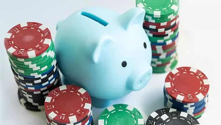 a white piggy bank and piles of casino chips 