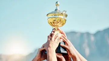 Holding a tournament gold cup aloft