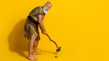 caveman playing an early game of golf