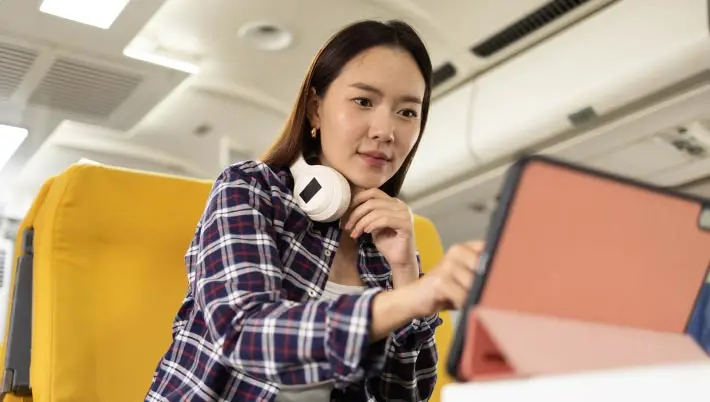 Smiling woman tourist looking at a mobile phone  