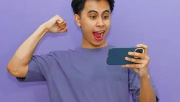 Young man playing on Grande Vegas on a mobile phone