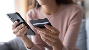 woman holding a smartphone and a credit card