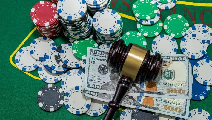 Casino chips, cards and money surrounding a gravel 
