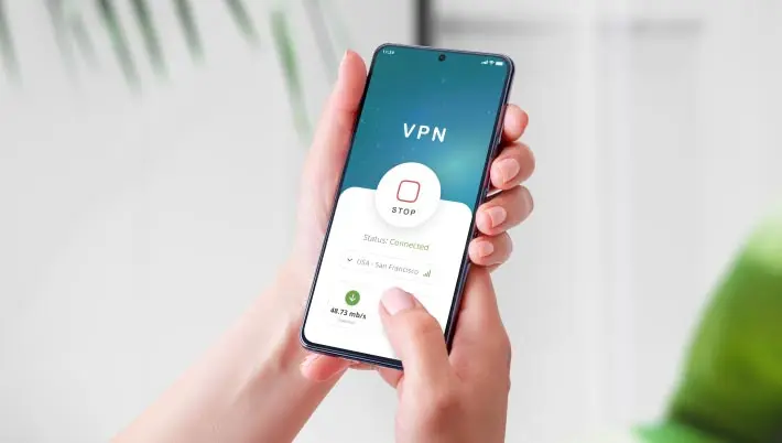 Woman holding a cell phone with "VNP" on the screen