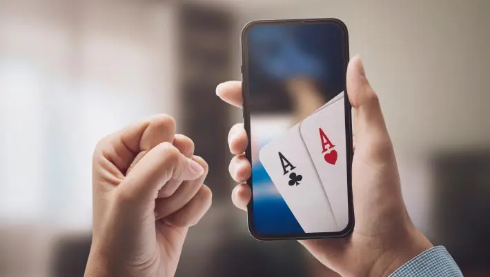 woman holding a mobile device that shows two aces