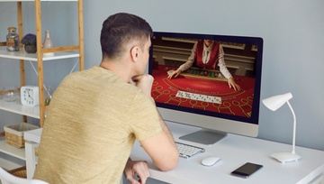 back view of a man playing poker games on a computer screen