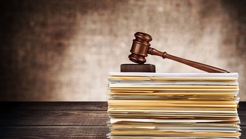 a pile of legal documents with a gavel sitting on top