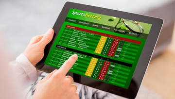 sports betting screen on a tablet with a guy about to click