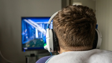 view from the back of a man playing a video game on his computer 